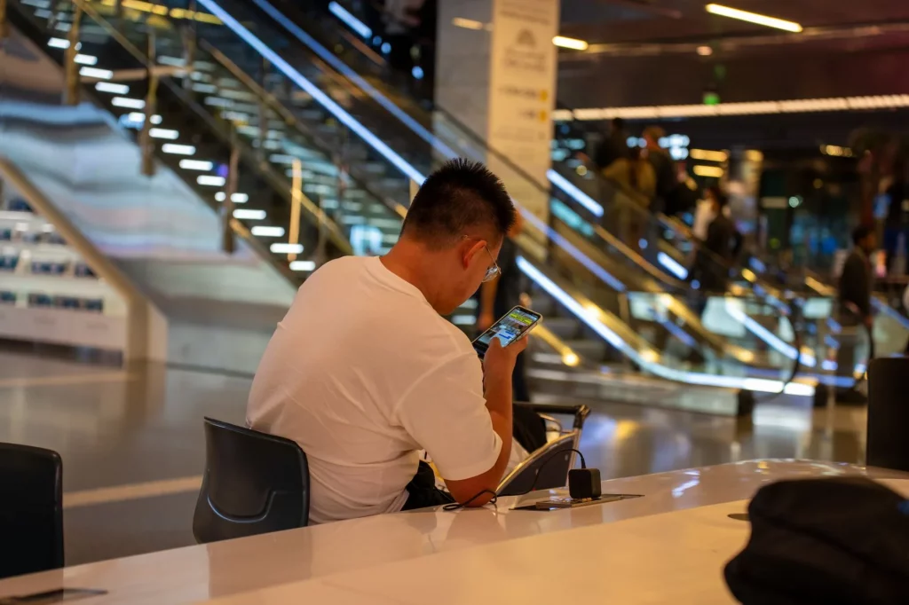 Traveller using a phone while waiting to depart