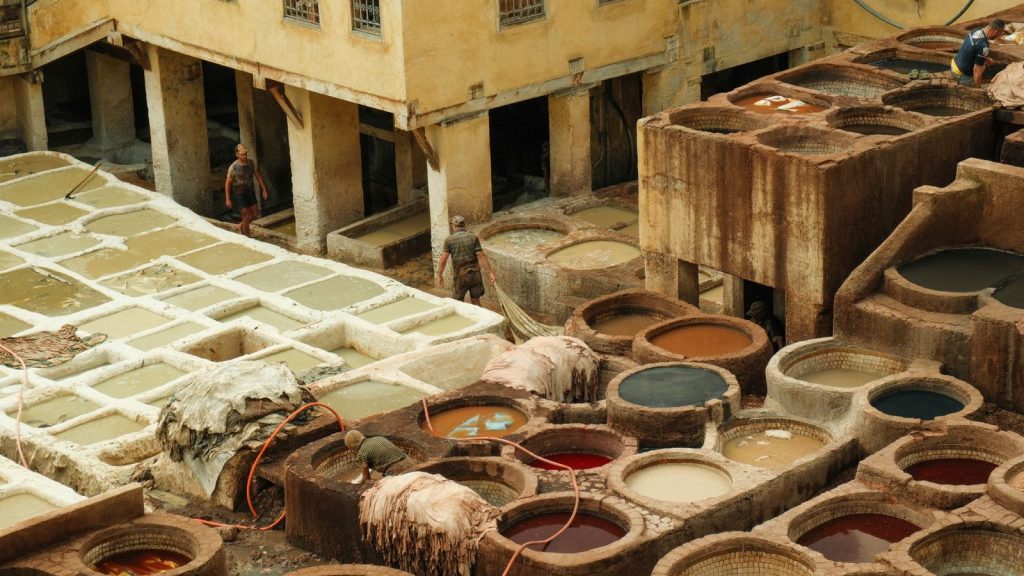 Aerial view of traditional tanneries in the old city of Fes, Morocco, showcasing the vivid dye pits.