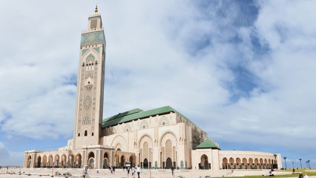 The iconic Hassan II Mosque in Casablanca under a blue sky, a key architectural masterpiece.