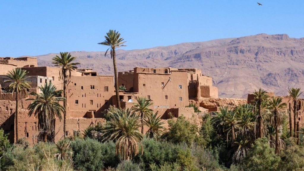 Picturesque view of a traditional Berber village with palm trees in the Atlas Mountains, Morocco.