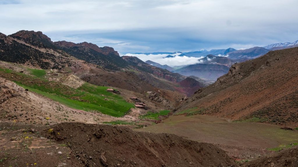 Vast scenic view of the Atlas Mountains in Morocco with lush greenery and rugged terrain.