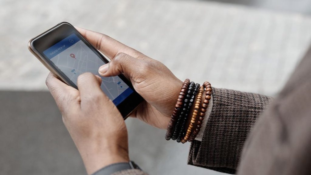 Close-up of hands holding a smartphone showing a map while travelling