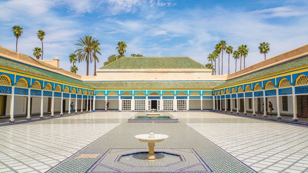 The great courtyard of the Bahia Palace in Marrakech, with its fountain, tiled floor and blue and yellow arcades